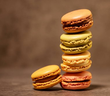 Koyu gri arka planda çok renkli badem kurabiyeleri