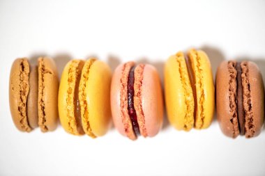 Beyaz arkaplanda çok renkli badem kurabiyeleri var.