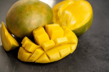 Olgun mango koyu gri arka planda küp şeklinde kesilmiş.