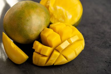 Olgun mango koyu gri arka planda küp şeklinde kesilmiş.