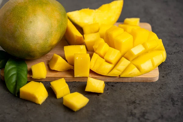 Olgun mango koyu gri arka planda küp şeklinde kesilmiş.