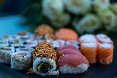 Suşi ve ekmekler bir tabak ardezya üzerine serilmiş.