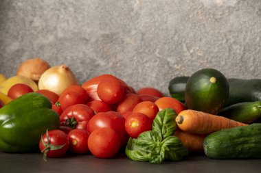 Gri bir masada taze sebzeler.