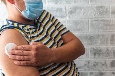 Sağlık görevlileri bir adama koronavirüs aşısı yapar.