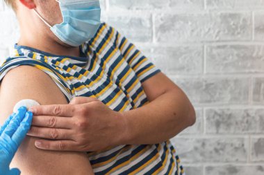 Sağlık görevlileri bir adama koronavirüs aşısı yapar.