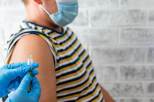 Sağlık görevlileri bir adama koronavirüs aşısı yapar.