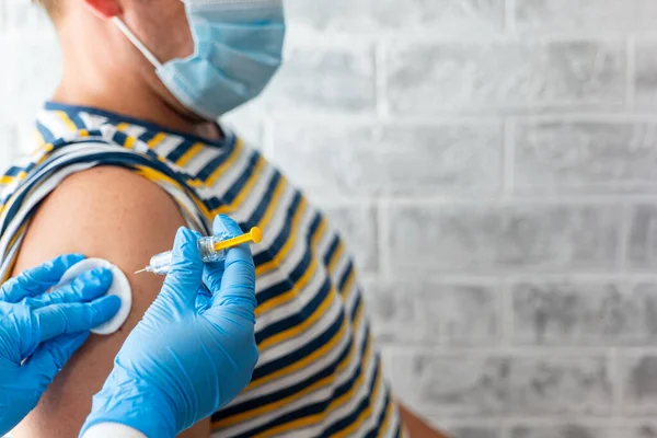 Sağlık görevlileri bir adama koronavirüs aşısı yapar.