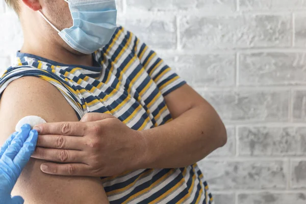 Sağlık görevlileri bir adama koronavirüs aşısı yapar.