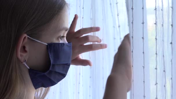 Ziek kind dragen beschermende masker in Coronavirus pandemie, triest kind op zoek naar venster, ongelukkig verveeld meisje in Covid-19 Crisis — Stockvideo