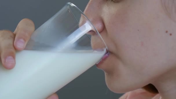 Gyerek ivóvíz tej a reggelinél, gyermek a konyhában, fiatal tinédzser lány kóstoló tejtermékek otthon — Stock videók