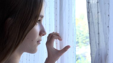 Hasta Üzgün Çocuk Coronavirus salgınında izole edilmiş Pencere Perdelerini Açıyor, Mutsuz Kız Dışarıya Bakıyor, Sıkıcı Çocuk