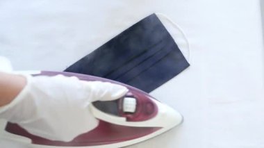 Koronavirüs salgınında dezenfekte için koruyucu maskeyi ütülemek, Covid-19 virüsü için buhar dezenfekte demiri kullanmak,