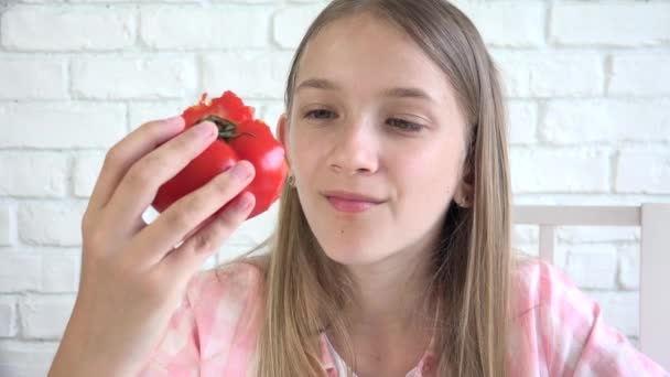 Kind eet tomaat, kind eet fruit, jong meisje proeft groenten bij het ontbijt in de keuken, kinderen Heathcare — Stockvideo