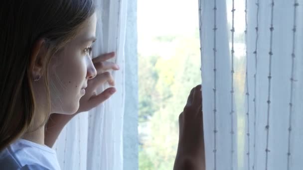 Больная грустная девочка, заразившаяся коронавирусом, пандемическое открывание оконных штор, несчастный ребенок, выглядывающий наружу на стекле, бородатый ребенок — стоковое видео