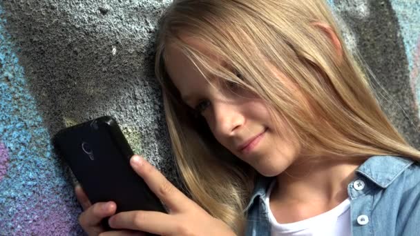 Criança brincando no smartphone no parque, Kid navegando na Internet no telefone inteligente, Loira adolescente menina digitando mensagens falando no dispositivo — Vídeo de Stock