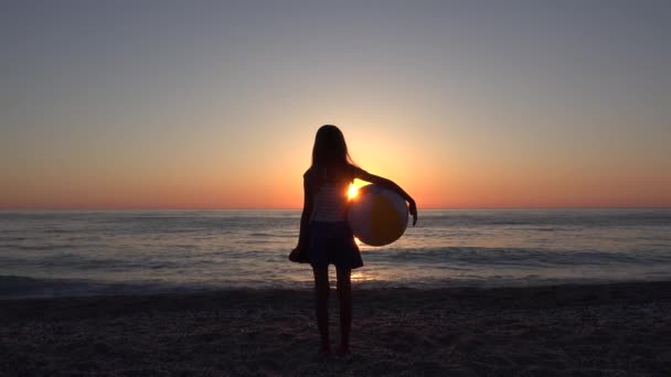 Bambino sulla spiaggia, Bambino che gioca sul mare al tramonto, Giovane ragazza sulla costa che guarda onde del mare in vacanza estiva — Video Stock