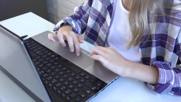 เด็กผู้หญิงเรียกดูอินเทอร์เน็ตบนแล็ปท็อป เด็กเรียนพิมพ์บนคอมพิวเตอร์ในโรคระบาดของไวรัสโคโรนา การเรียนรู้ของเด็ก การศึกษาในโรงเรียนออนไลน์ — วีดีโอสต็อก