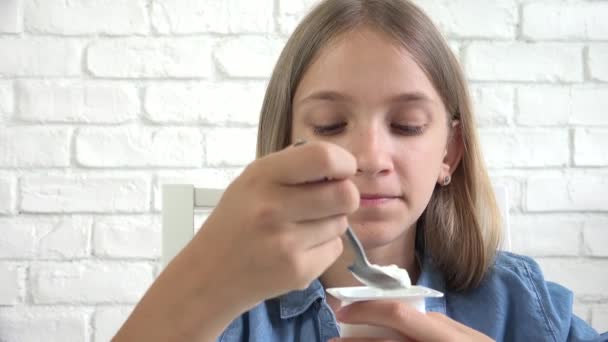Gyermek Eating Joghurt, Gyerek Eats Tejtermékek, Fiatal Lány a Reggeli Konyhában, Gyerekek Egészségügy — Stock videók