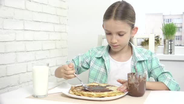 Barn Förbereda pannkakor på frukost, Kid äta choklad i köket, Flicka förbereder Griddle-kaka hemma — Stockvideo