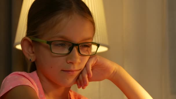 Niño leyendo un libro, Niño que estudia en la lámpara de escritorio, Gafas graduadas de estudiante Aprendizaje de niñas en la noche, Educación para niños, Educación en el hogar — Vídeo de stock