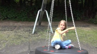 Çocuk parkta oyun oynuyor, çocuk sallıyor, sarışın mutlu, gülümseyen kız dışarıda dinleniyor, çocuk mutluluğu.