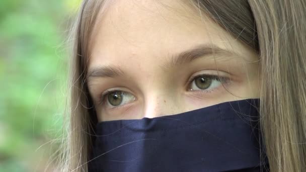 Больной ребенок в защитной маске из-за пандемии коронавируса, грустная девочка, изолированная в парке, скучающий несчастный подросток, не играющий — стоковое видео