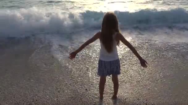 Enfant jouant sur la plage de la mer au coucher du soleil, Enfant regardant les vagues de l'océan sur la côte, Blonde fille portrait sur la côte en vacances d'été — Video