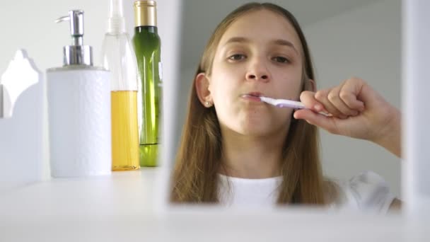 Niño cepillando dientes de bebé en el espejo, Lavado de niños pequeños con cepillo de dientes, Chica rubia en el baño, Cuidado de la salud adolescente — Vídeo de stock