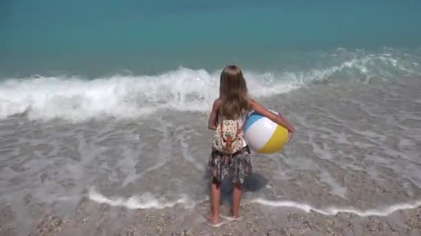 Dziecko bawiące się na plaży o zachodzie słońca, Happy Isolated Kid with Beach Ball Walking in Sea Waves, Dziewczyna na wybrzeżu w letnie wakacje — Wideo stockowe