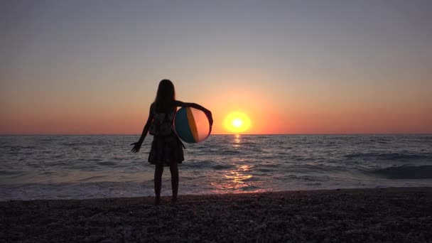Dziecko na plaży, Dziecko bawiące się nad morzem o zachodzie słońca, Dziewczynka na wybrzeżu oglądająca fale morskie w wakacje — Wideo stockowe