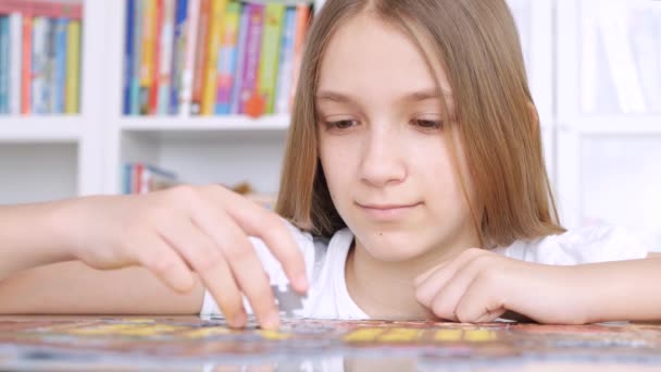 Kid gör pussel, uttråkad barn spelar smarta spel hemma, tonåring flicka spelar brädspel inomhus — Stockvideo