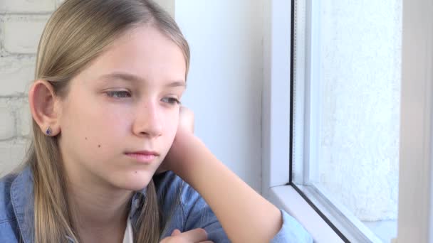 Enfant triste regardant par la fenêtre, enfant malheureux, fille réfléchie ennuyée, visage d'adolescent, personnes isolées à la maison dans les crises de coronavirus — Video