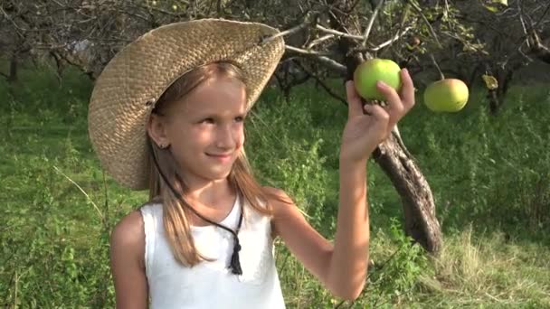 Παιδί που τρώει μήλο, παιδί στον οπωρώνα, παιδί που δοκιμάζει φρούτα στο δέντρο, αγρότης ξανθιά κοπέλα στο χωριό στην ύπαιθρο — Αρχείο Βίντεο