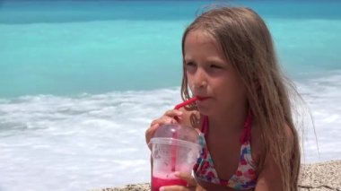 Sahilde buzlu içecek içen çocuk, sahilde oynayan çocuk, yaz tatilinde sahilde susamış genç kız portresi.