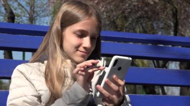 Park 'taki Smartphone' da Çocuk Bakımı İnternet, Bench 'te Açık Alan, Akıllı Telefon Oynayan Ergen Kız Aygıtları