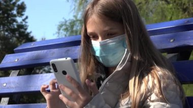 Korunma Maskeli Hasta Çocuk Akıllı Telefonla Oynuyor, Üzgün Çocuk Park 'ta Akıllı Telefon Kullanıyor, Koronavirüslü Kız Salgını