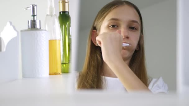 Chica cepillando dientes de bebé en el espejo, Lavado de niños pequeños con cepillo de dientes, Niño rubio en el baño, Cuidado de la salud adolescente — Vídeo de stock