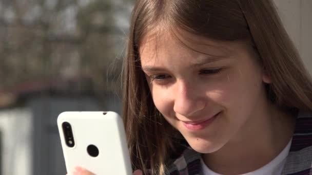 Kid playing Smartphone, tiener kind surfen op internet op Smart Phone in het park, Adolescent Girl use Apparaten Outdoor op Speelplaats — Stockvideo