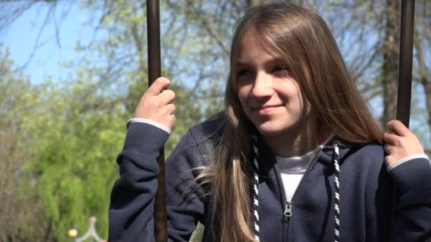 Bambino che oscilla al parco giochi nel parco, Bambino che gioca all'aperto nella natura, Ragazza riflessiva che si rilassa nella foresta, Ritratto di ragazza sorridente — Video Stock