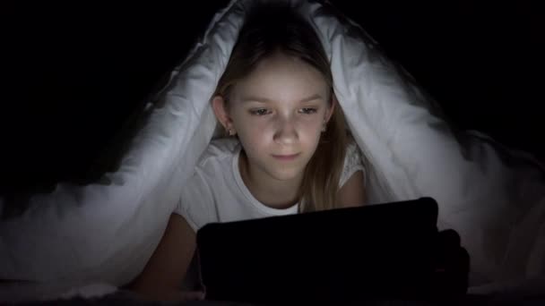 子供が夜にタブレットをプレイ,ベッドでインターネットを閲覧女の子,子供がデバイス上で検索スタッフを寝ていない,子供がゲームをプレイ — ストック動画