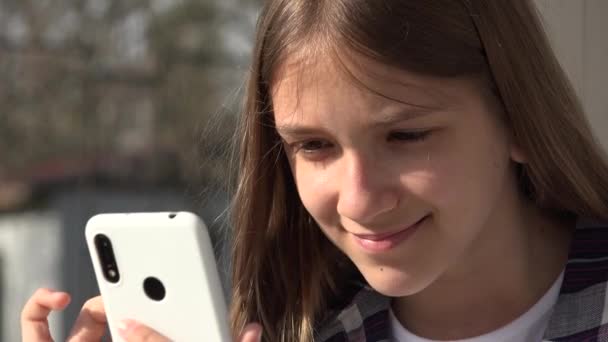 Menina adolescente jogando Smartphone, Kid navegando na Internet no telefone inteligente no parque, Dispositivos de uso de crianças adolescentes ao ar livre no parque infantil — Vídeo de Stock