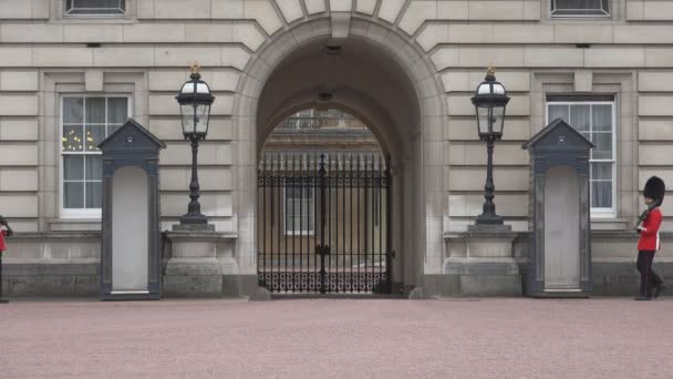 Лондонский Букингемский дворец, вооруженная английская гвардия марширует и охраняет, фасады, здания достопримечательностей в Европе — стоковое видео