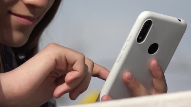 Kid playing Smartphone, Teenager Child Browsing Internet na chytrém telefonu v parku, Dospívající Dívka použití zařízení venkovní na hřišti — Stock video