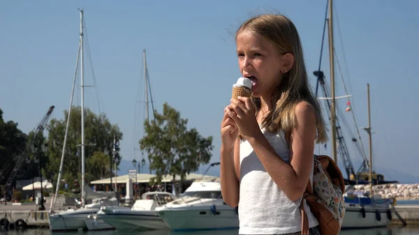 子供がアイスクリームを食べる シーポートでビーチで子供 ボートでブロンドの女の子 海岸で船港 夏休みの子供たち ストック写真