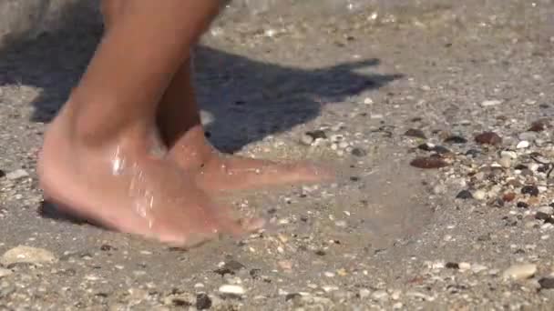 Barfuß am Strand spielend, Kinderfüße plantschendes Meerwasser am Strand, glückliches kleines Mädchen an der Küste im Sommerurlaub — Stockvideo