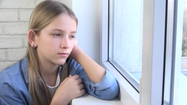 Criança triste olhando na janela, criança infeliz, menina pensativa entediada, rosto adolescente, pessoas isoladas em casa em crises de coronavírus — Vídeo de Stock