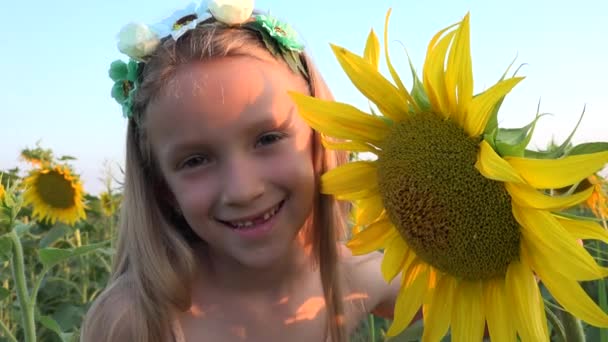 Copilul în domeniul agriculturii floarea-soarelui, Copilul se joacă în recolta agrară, Fata fermier joacă în prerie, Copiii în aer liber în natură — Videoclip de stoc