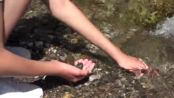 Dítě sbírání říčního kamene z horského vodopádu, Kid hraje v říční vodě, Dívka ruce v jarním vodopádu, Turistika v kempu — Stock video