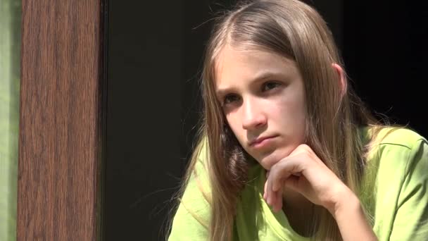 Trauriges Kind, das aus dem Fenster schaut, unglückliches Mädchen, gelangweiltes nachdenkliches Kind, Teenager-Gesicht, isolierte Menschen zu Hause in Coronavirus-Krisen — Stockvideo