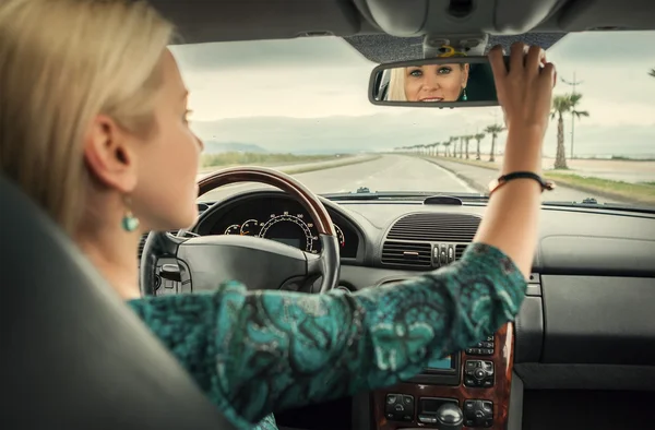 Woman in car looking in mirror — Stock Photo, Image